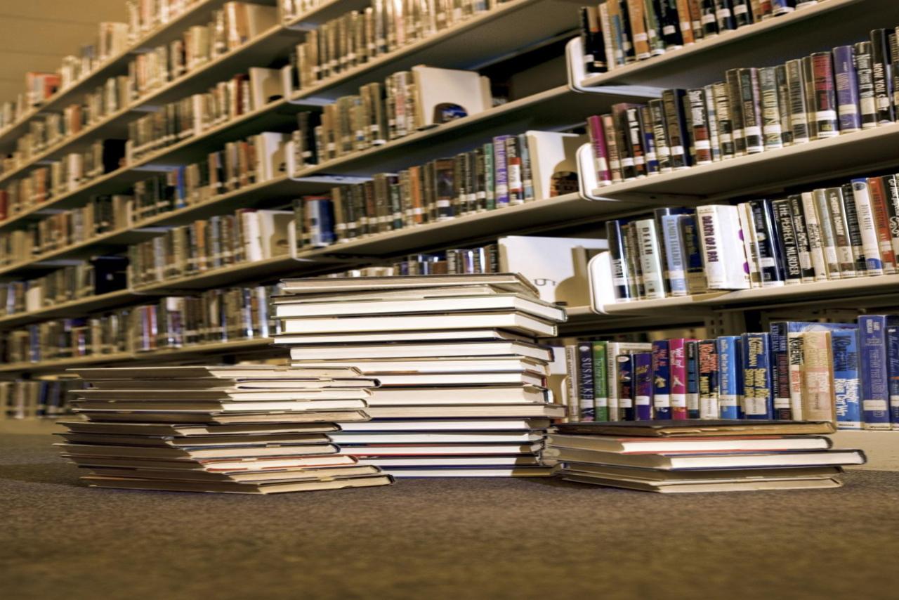 stack of books in library in front of shelf