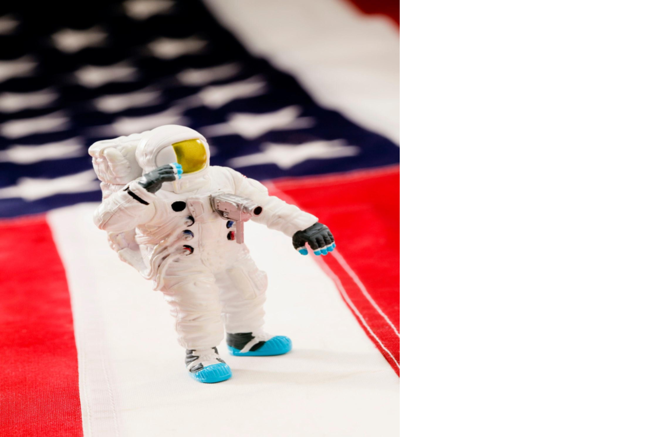 American flag background with toy astronaut standing on top