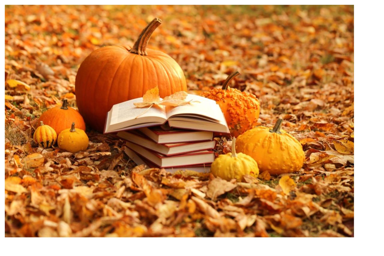 fall leaves background with stack of pumpkins and books 