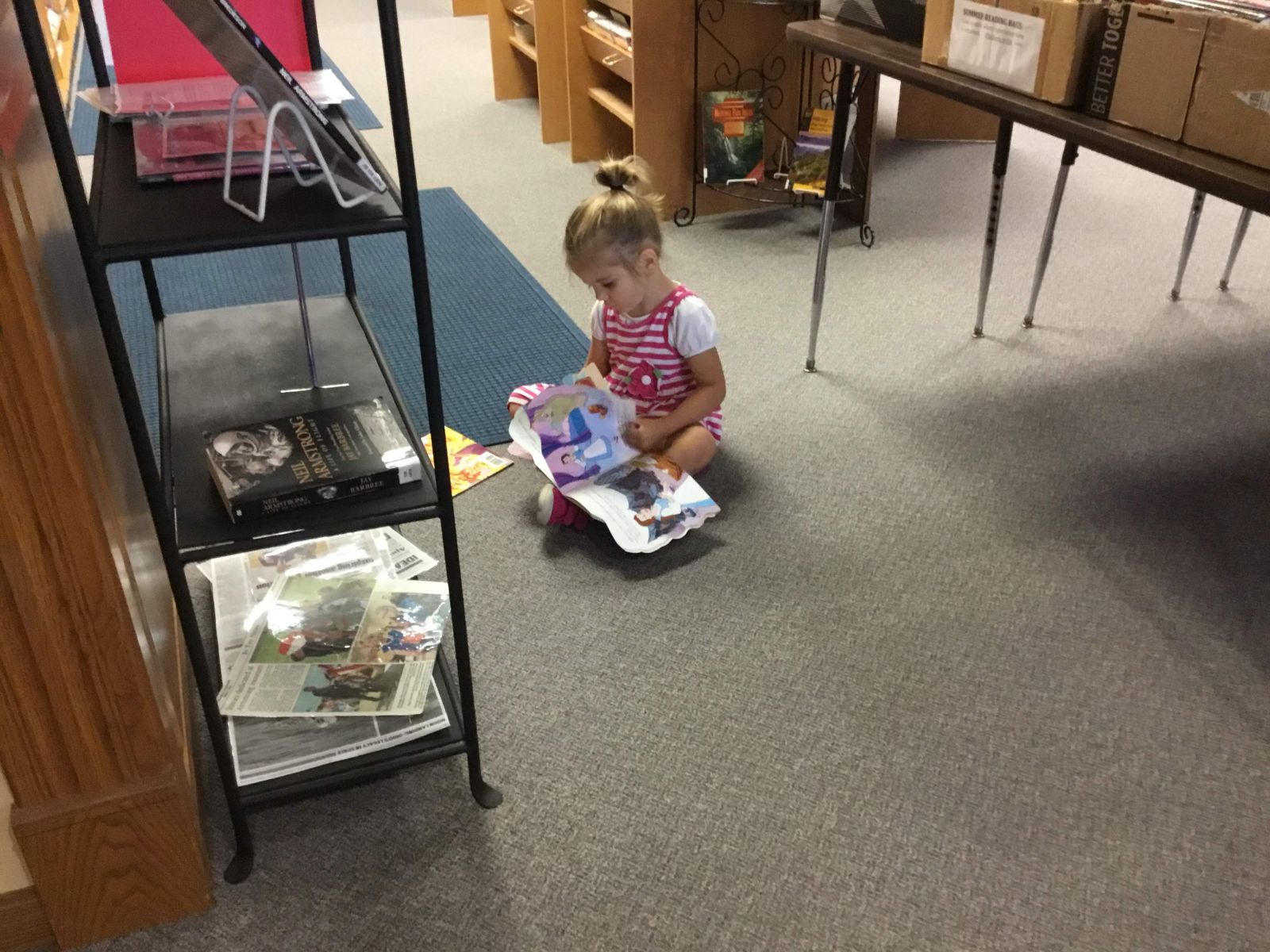 picture of little girl reading a book at the book sale